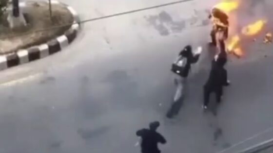Man burning alive in the middle of the street screams in pain as people try to put out the fire Photo 0001 Video Thumb