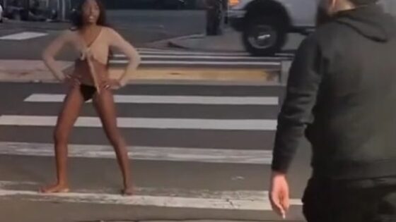Woman walking down the street half undressed in total disregard for other people Photo 0001 Video Thumb