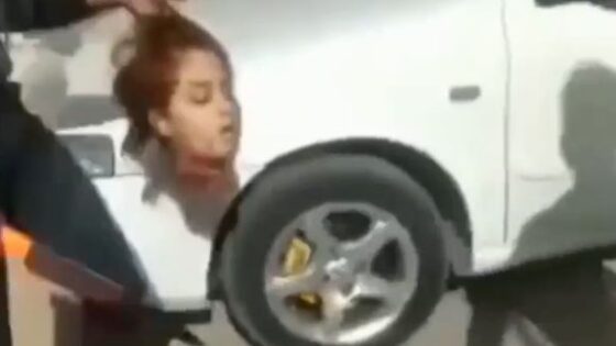 Man carrying a womans beheaded head in the middle of the street during the day in some middle eastern country Photo 0001 Video Thumb