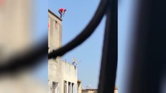 Camera man captures the perfect shot of a man leaping off of building Photo 0001 Video Thumb